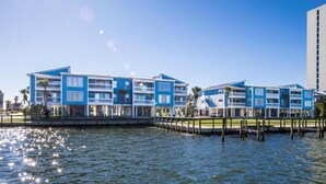 Ein Hotel am Wasser mit mehreren Balkonen, einem Pool und Blick auf das Wasser.
