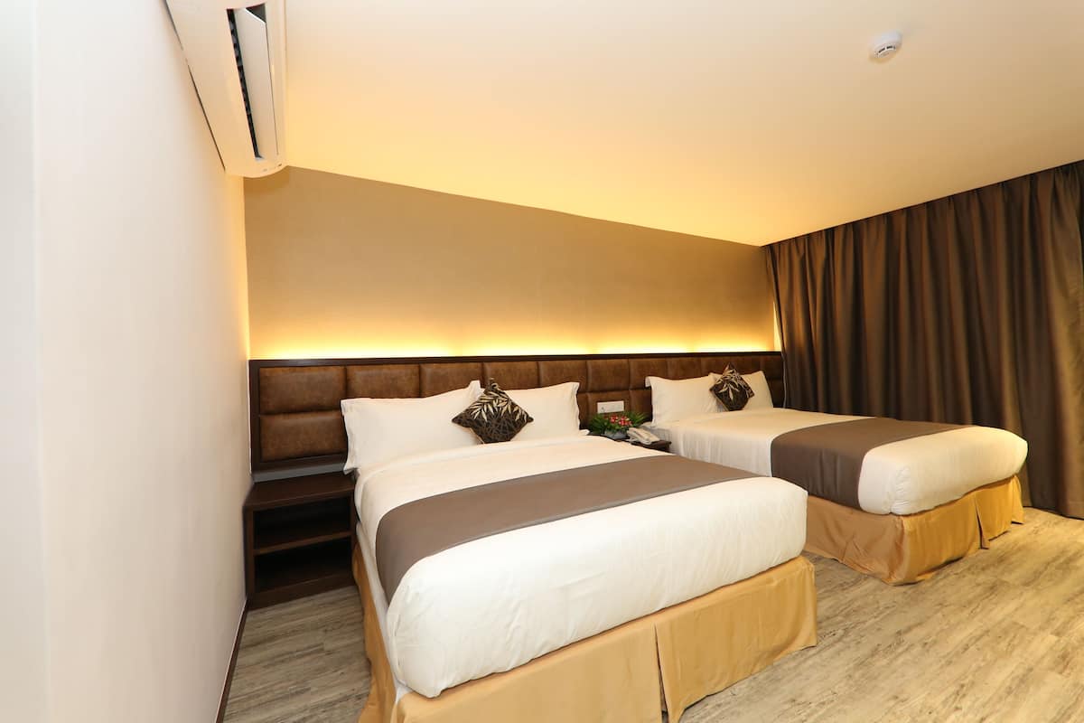 A hotel room with two beds, a large window, and a built-in air conditioning unit.