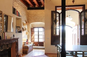 A spacious living area with a fireplace, a large window, and a dining table.