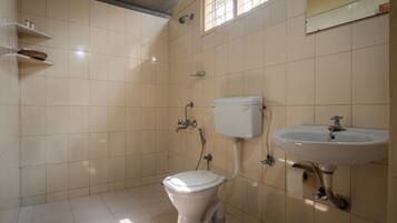 A bathroom with a toilet, sink, and shelves with toiletries.