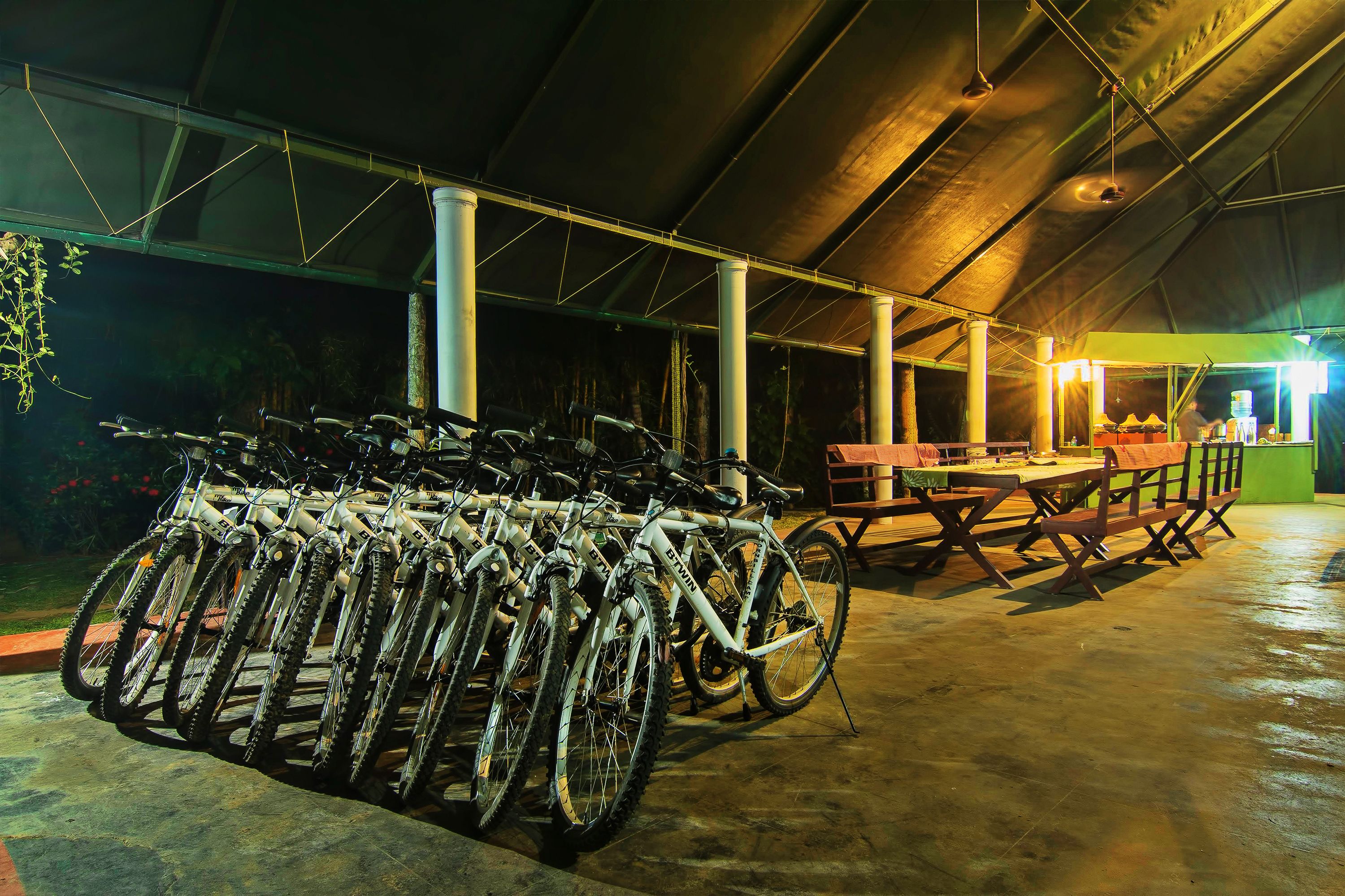 A covered outdoor area with a bicycle rack and a dining table with chairs.