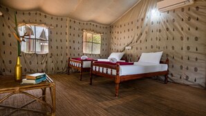 A room with two wooden beds, a ceiling fan, an air conditioning unit, and a window with curtains. - Amritara Riverside Camp, Thattekad (Kothamangalam)