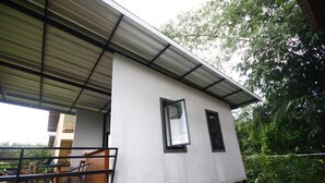 Un edificio moderno con techo plano y balcón con mobiliario exterior.