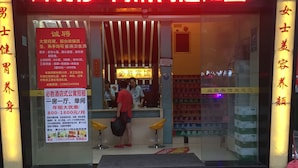 A hotel entrance with a red sign, a reception desk, and a tiled floor. - Victory hotel (Guangzhou)