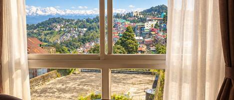 A room with a view of a mountainous landscape through a window.
