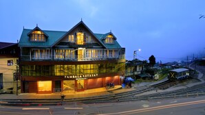 Un bâtiment sur lequel on peut lire l’inscription « Zambala Retreat ». Il présente un style architectural traditionnel, avec de nombreuses fenêtres et un balcon.