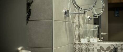 A bathroom with a sink, mirror, and towel rack.