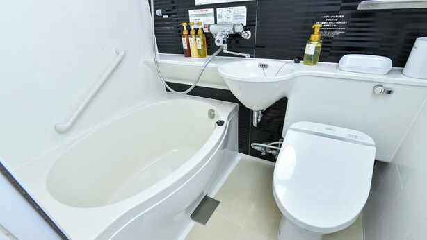 A modern bathroom with a bathtub, a sink, and a toilet. - Sanco Inn Nagoyashinkansenguchi Annex (Nagoya)