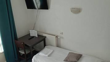 Une chambre d’hôtel avec deux lits, un bureau doté d’un téléviseur à écran plat, une chaise et une fenêtre avec des rideaux.
