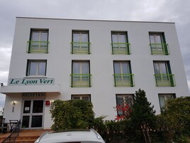 Um edifício com vários andares, varandas, área de recepção e um letreiro com a inscrição 