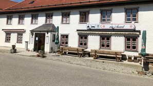 A traditional building with a red-tiled roof, multiple windows, and outdoor seating. - Zur Auszeit (Traunreut)