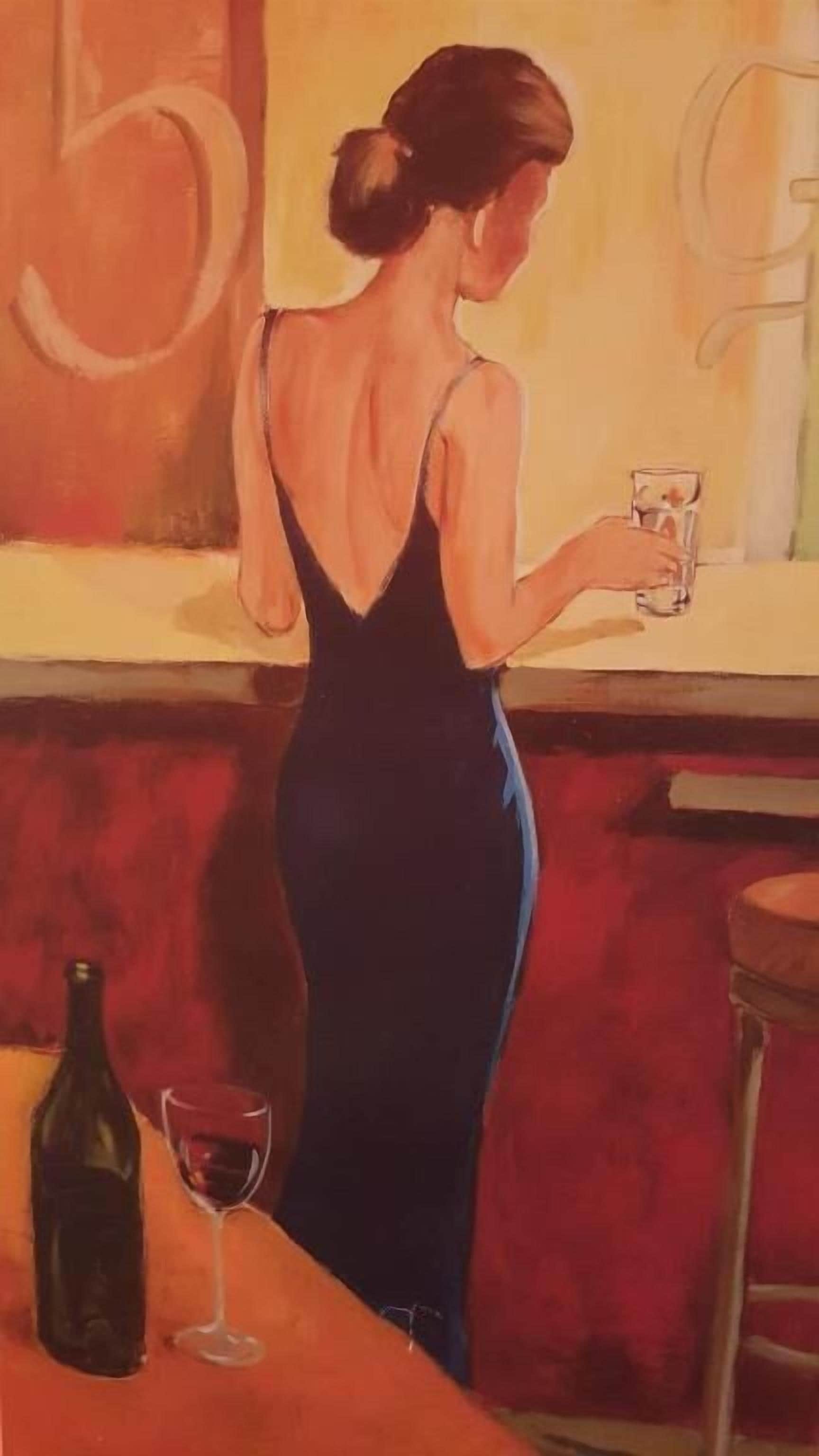 A woman in a black dress standing at a bar counter with a glass of wine and a bottle on the counter.