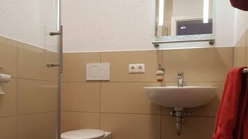 Ein Badezimmer mit Toilette, Waschbecken und Duschkabine.