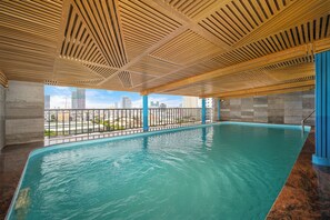 An indoor swimming pool with a view of the cityscape. - Platinum Danang Hotel (Da Nang)