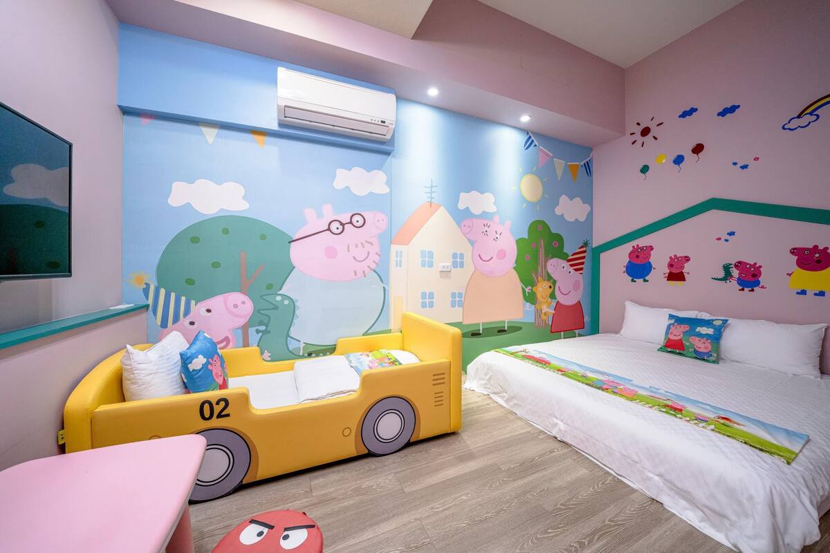 A children's room with a bed, a play area with a toy car, and a mural on the wall.