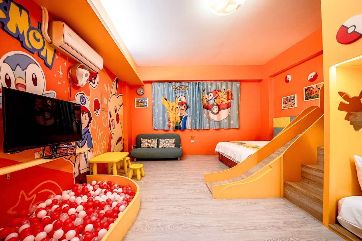 A brightly colored room with a play area, a sofa, a TV, and a slide.