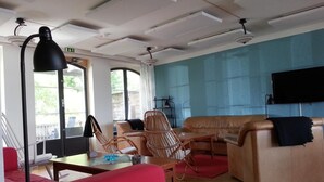 A living room with a sofa, chairs, a table, and a TV. - Fjällbacka Pensionat & Vandrarhem (Fjallbacka)