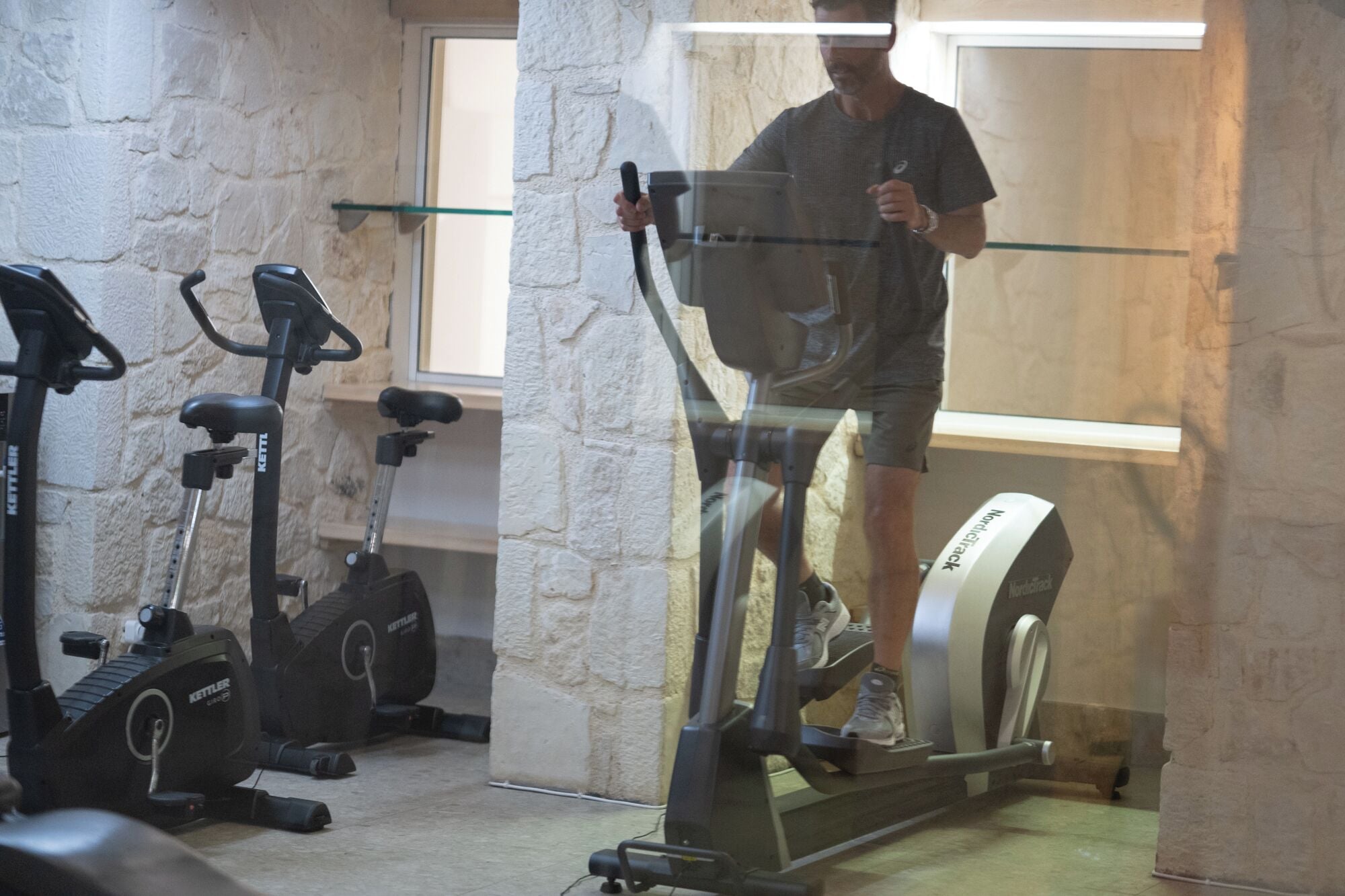 Una palestra con attrezzature per esercizi, tra cui tapis roulant e cyclette.