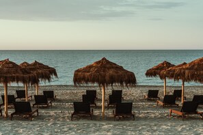 位於海灘上、躺椅、遮陽傘