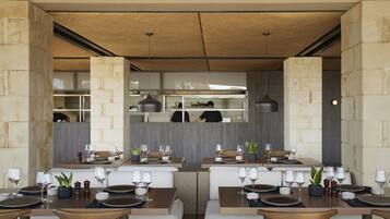A modern restaurant with booth seating, wooden tables, and a stone accent wall.