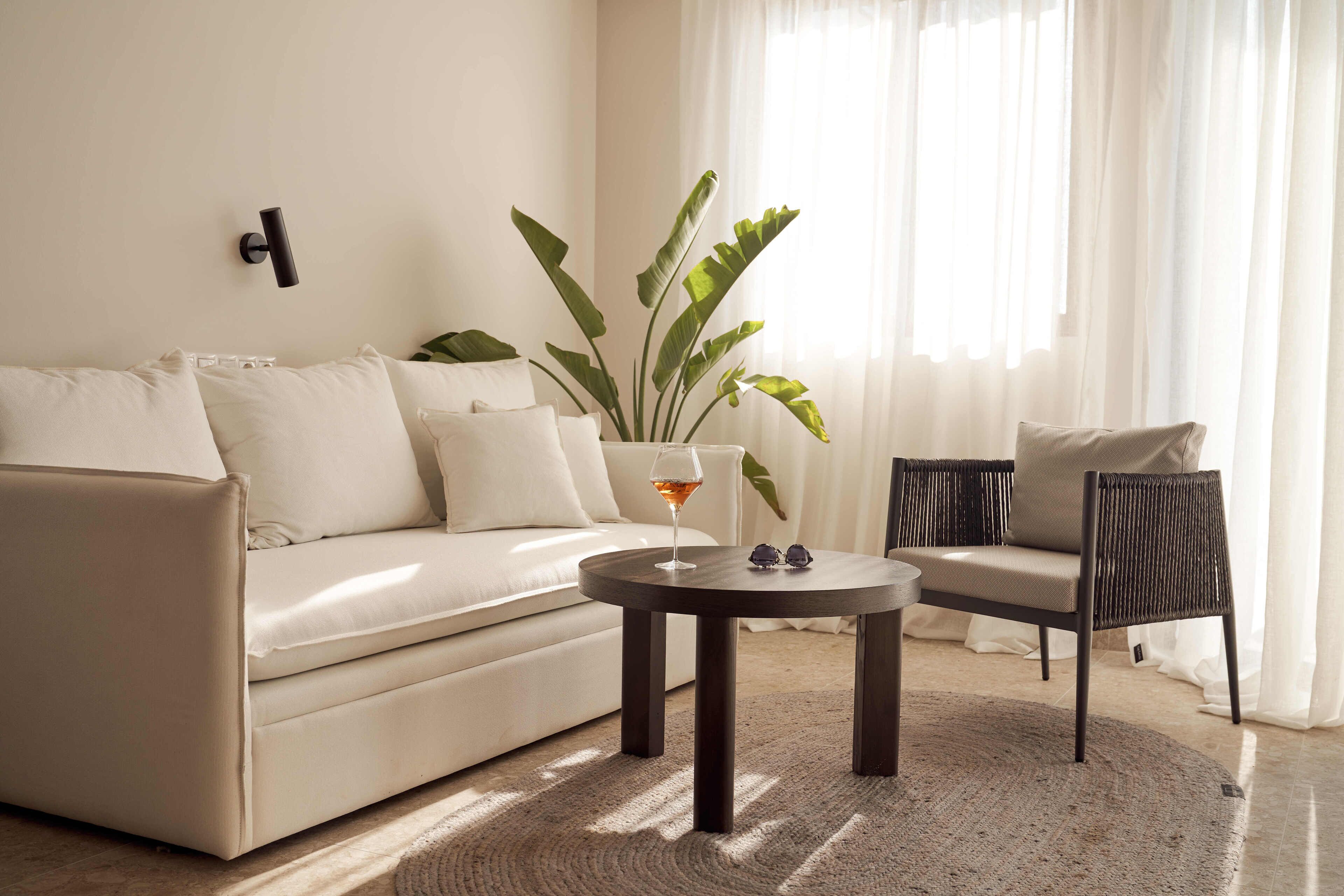 A modern living room with a sofa, a round coffee table, and a chair.