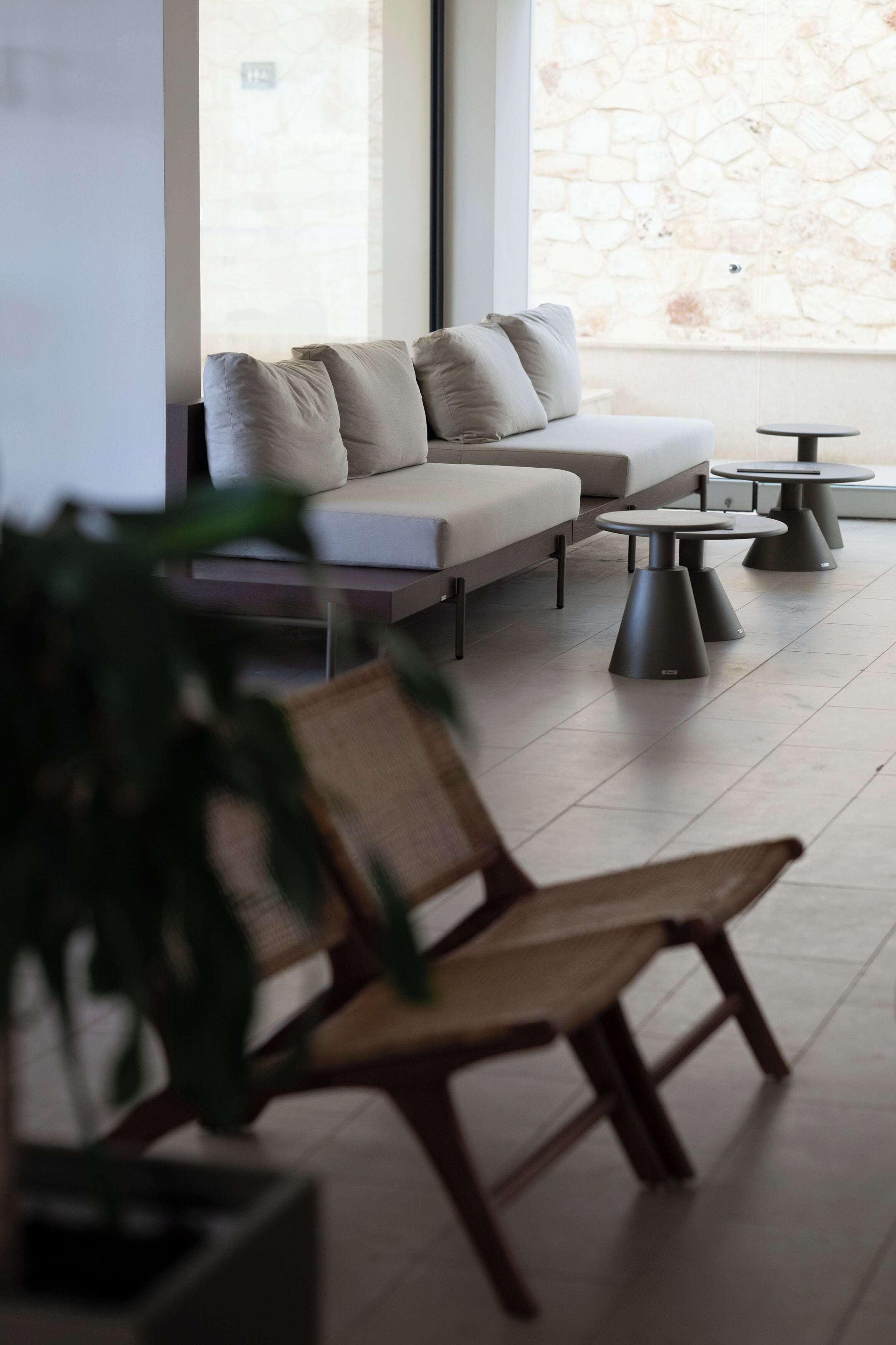 A modern lounge area with a sofa, chairs, and round tables.