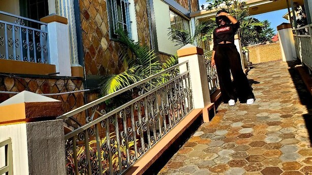 A building with a stone facade, multiple windows, and a metal railing along a pathway. - Gahahe Hills Hotel (Bujumbura)