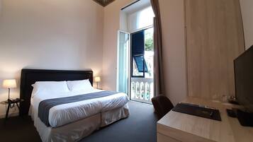 Une chambre d’hôtel équipée d’un lit, d’une lampe de chevet, d’un bureau et d’un téléviseur.
