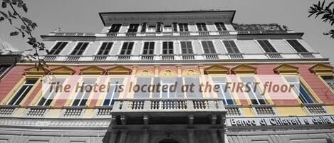 A hotel with a classical facade, featuring a prominent entrance with columns and decorative ironwork.