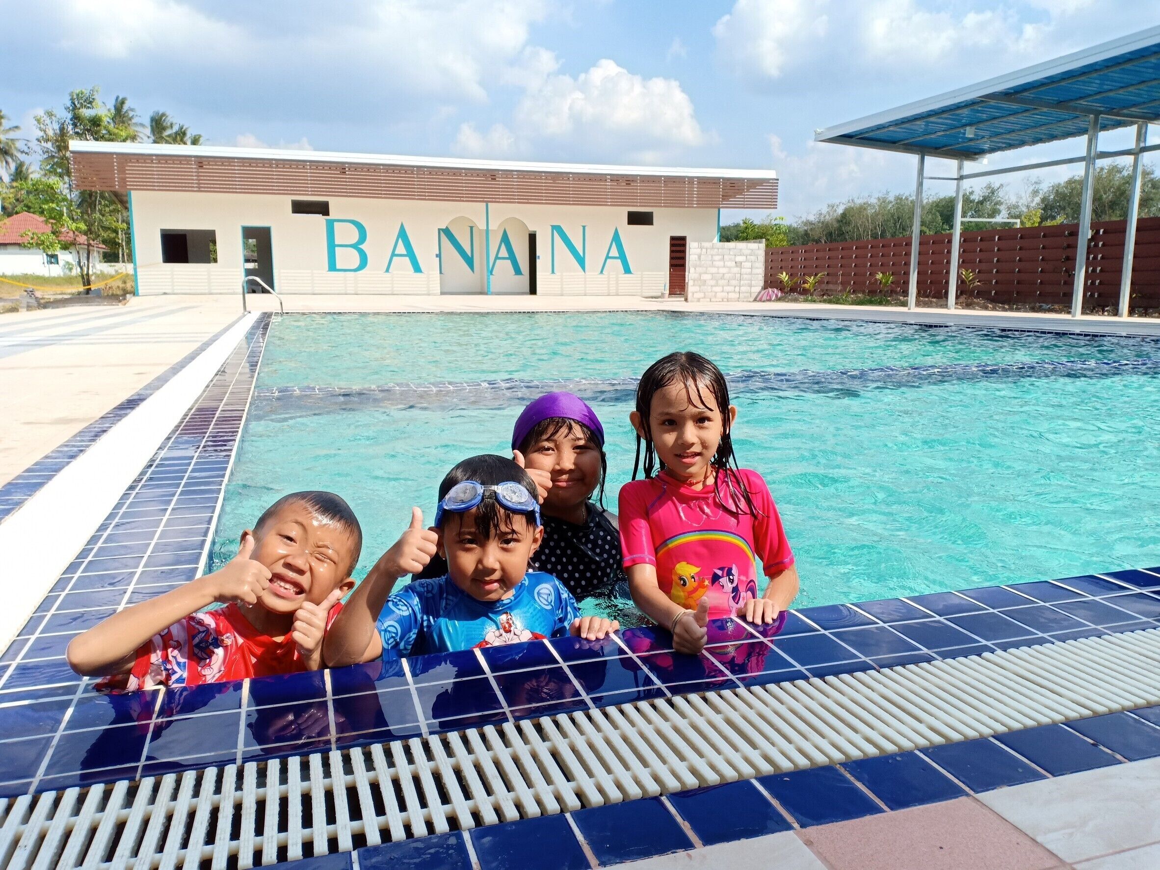 A swimming pool with a building labeled "BANANA" in the background.