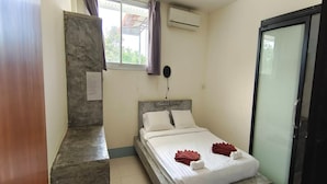 A small, clean room with a bed, a window with curtains, an air conditioning unit, and a door. - Top Harvest Rental - Hostel (Ko Pha-ngan)