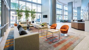 A spacious lobby with a sofa, armchairs, a coffee table, and a reception desk.