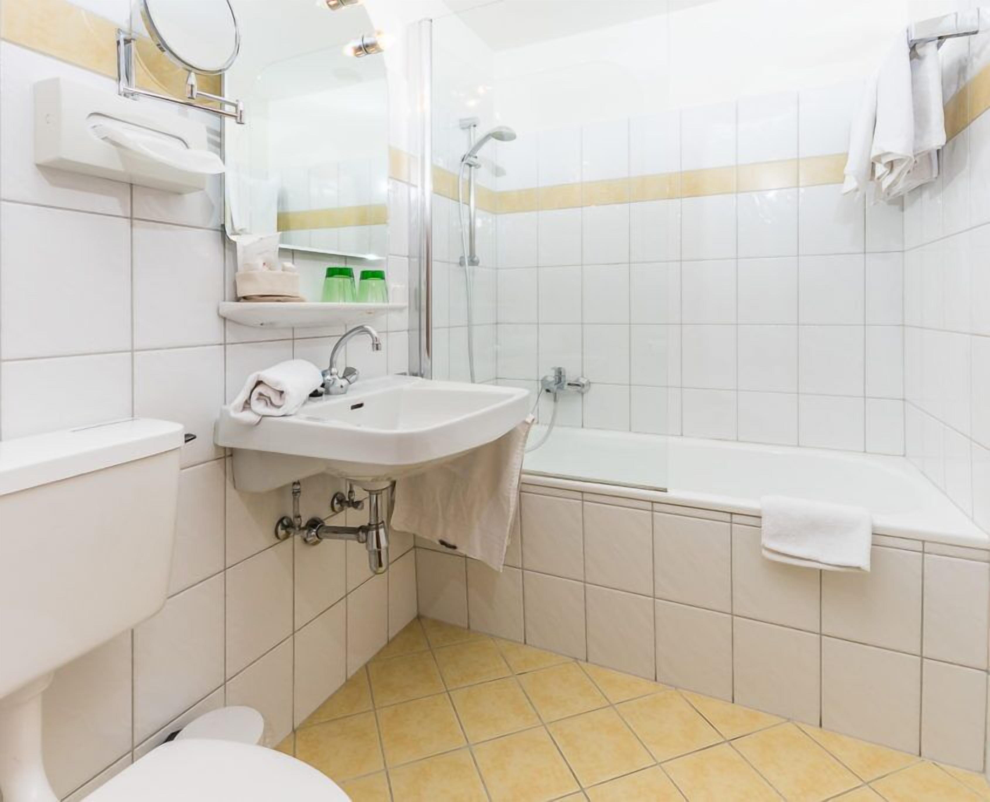 Une salle de bain moderne équipée de toilettes, d’un lavabo et d’une baignoire.