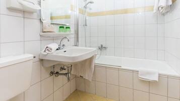 Une salle de bain moderne équipée de toilettes, d’un lavabo et d’une baignoire.