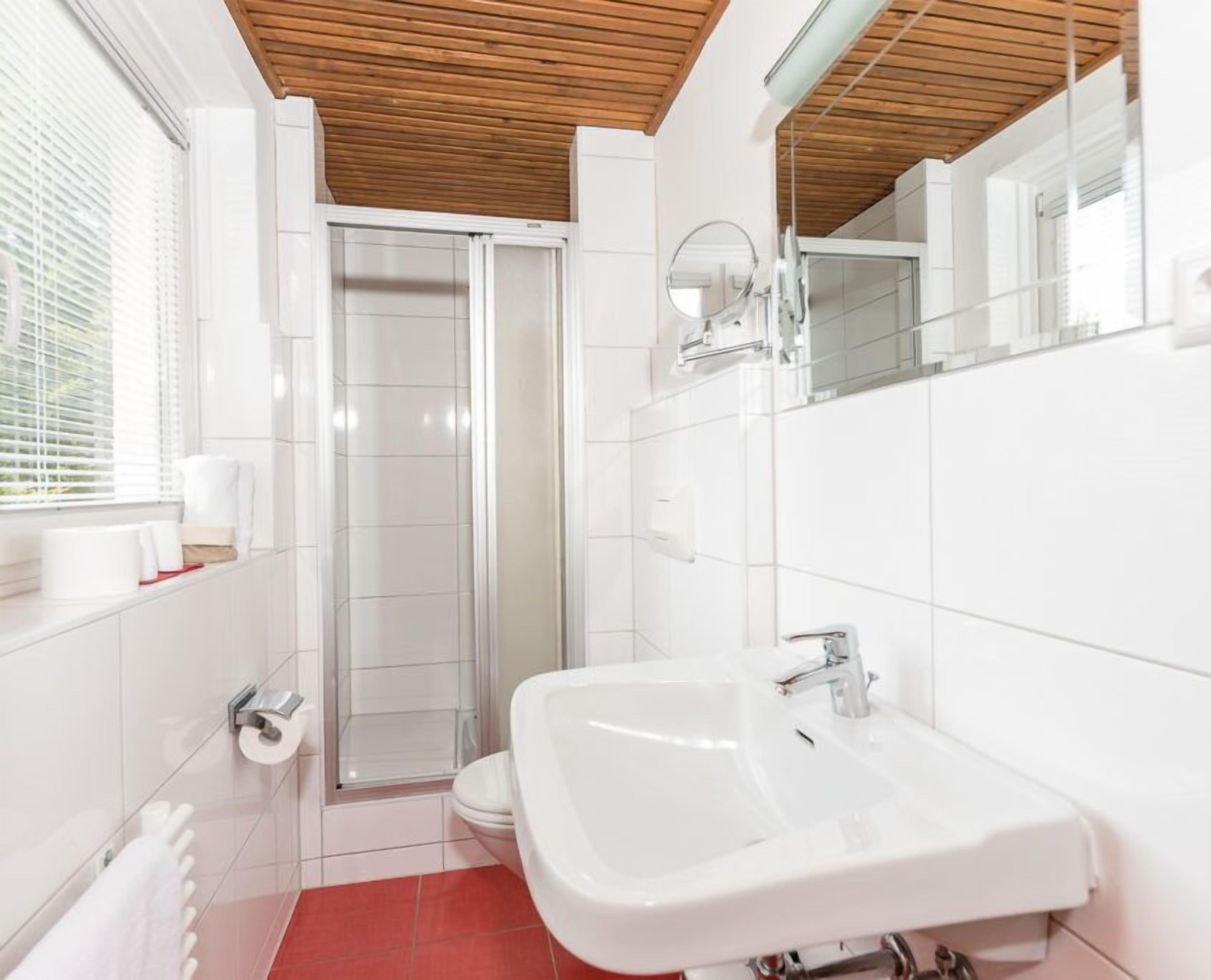 A modern bathroom with a shower, toilet, and sink.