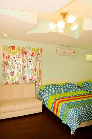 A bedroom with a bed, a sofa, a ceiling fan, and a window.