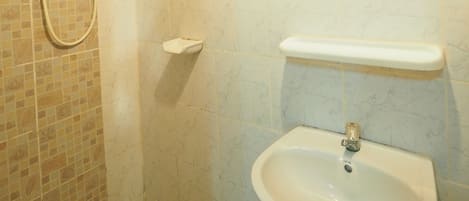 A bathroom with a shower, a sink, a mirror, and a towel rack.