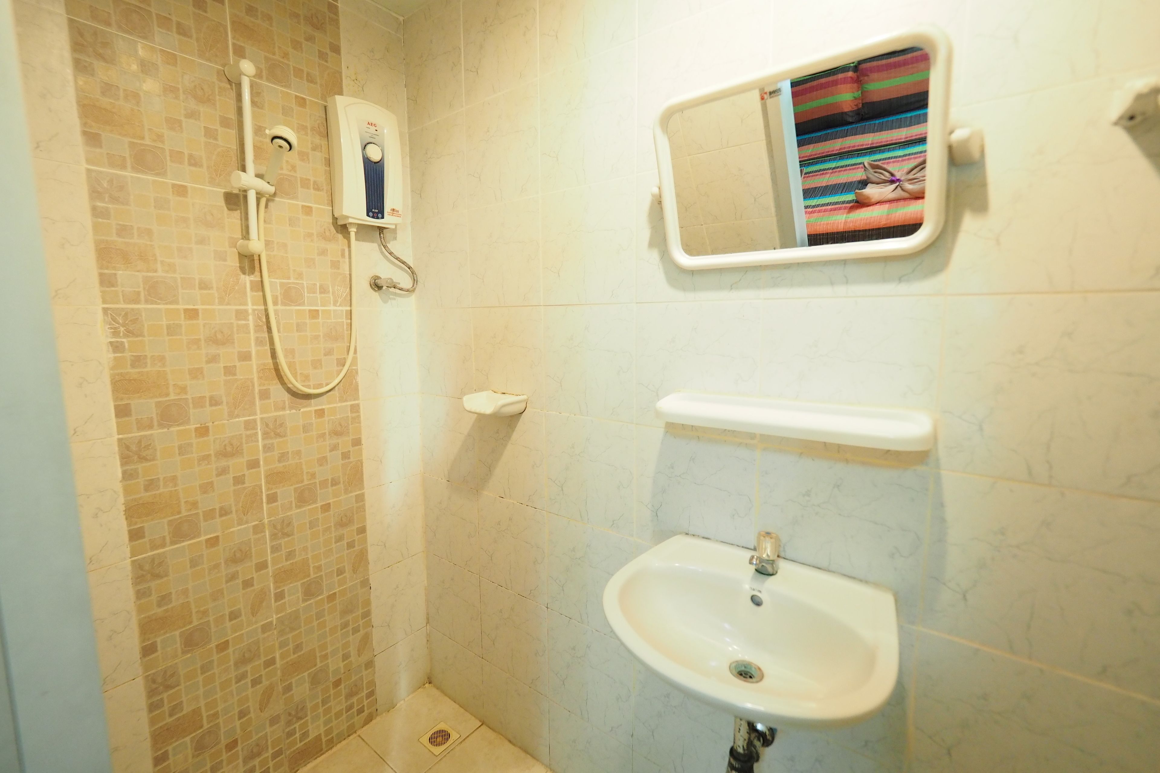 Un baño con ducha, lavamanos y espejo.