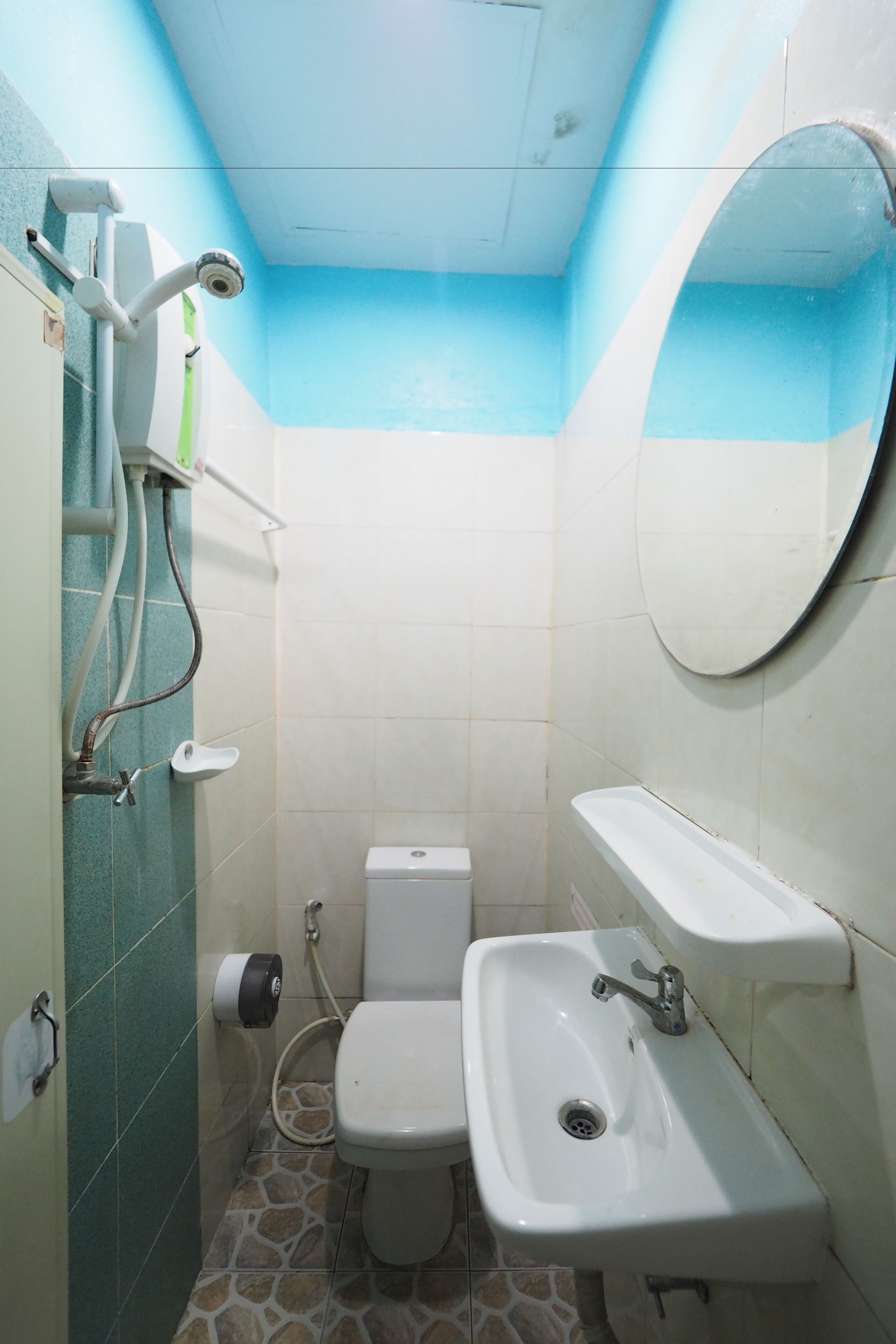 A small bathroom with a toilet, sink, and a mirror.