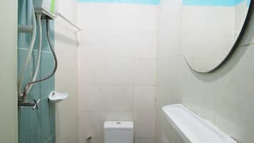 A small bathroom with a toilet, sink, and a mirror.