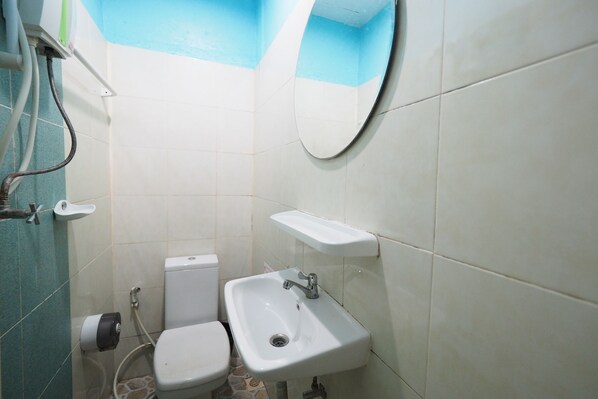 Un baño pequeño con inodoro, lavamanos y espejo.