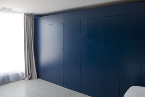 A modern bedroom with a large window, a built-in wardrobe, and a minimalist design. - La Reine Jane (Hyères)