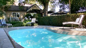 A swimming pool with lounge chairs and a house in the background. - The Giraffe Inn at Old Parks Manor (Napa)