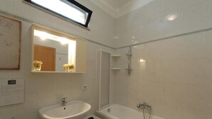 Un baño con lavamanos, espejo y bañera.