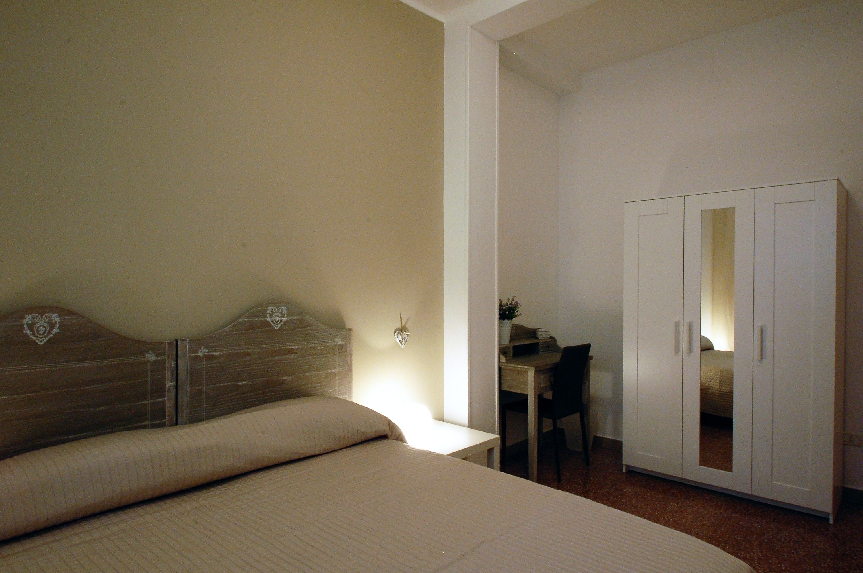 Una camera da letto con un letto, una scrivania e un armadio.