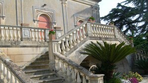 A grand staircase with ornate balustrades leading to a building entrance. - Villa Papaleo (Bagnolo del Salento)
