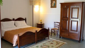 A bedroom with a wooden bed, a nightstand, a chair, and a wardrobe. - Villa Papaleo (Bagnolo del Salento)