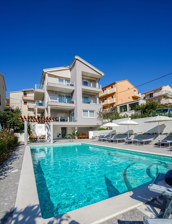 Piscine extérieure, parasols de plage, chaises longues