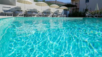 Piscine extérieure, parasols de plage, chaises longues