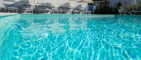 Piscine extérieure, parasols de plage, chaises longues